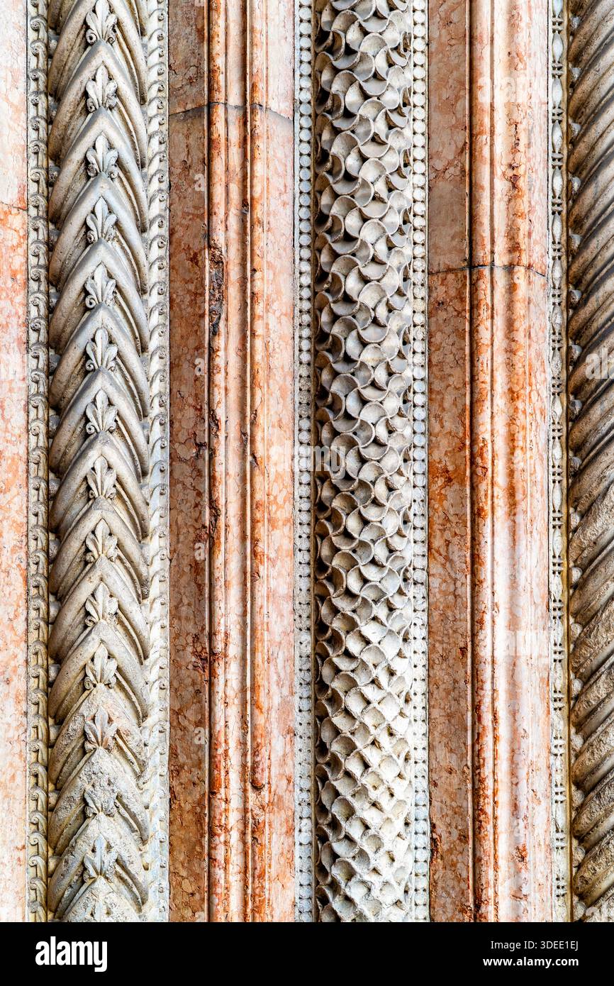 Primo piano di colonne architettoniche ornate con motivi e trame intricati, che presentano un mix di finiture in pietra e marmo Foto Stock