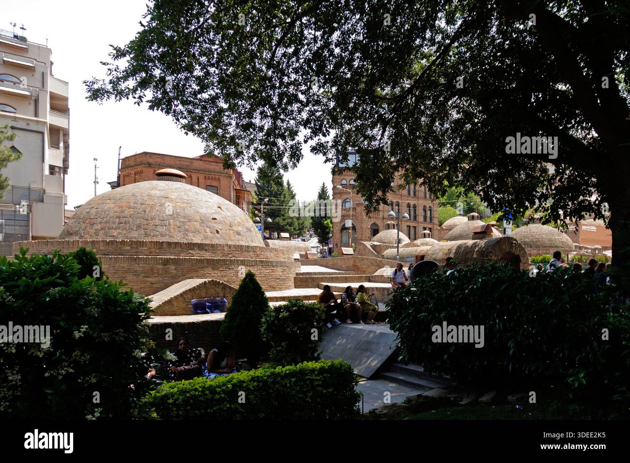 Le cupole in mattoni delle vecchie terme zolfo nel quartiere di Abanotubani, circondate da un giardino verde, Tbilisi Georgia Foto Stock