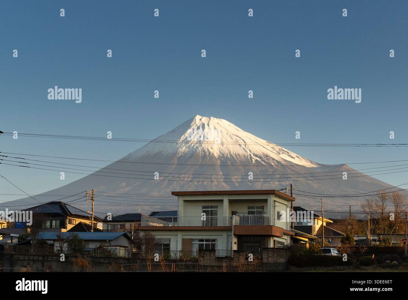 Monte Fuji, Giappone. Un maestoso vulcano innevato incombe su una tranquilla area residenziale, che mostra la serena bellezza del paesaggio giapponese. Foto Stock