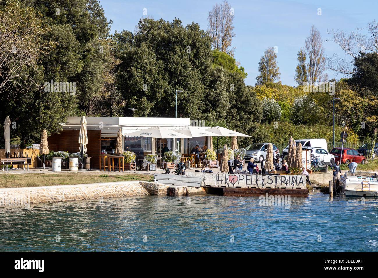Pellestrina, Venezia, Italia - 25 ottobre 2025: Caffetteria all'aperto con terrazza con vista sul lungomare sul molo dell'isola Foto Stock