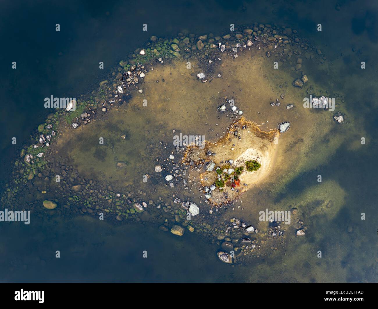 Vista aerea di una piccola isola con bordi rocciosi e un gruppo di alberi intorno a un edificio, circondata da acque blu profonde, New London, New Hampshire, uni Foto Stock