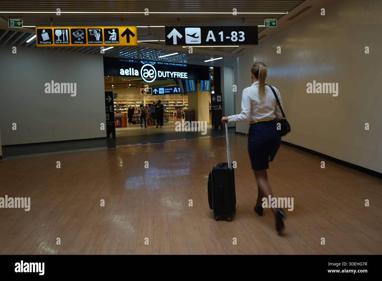 Un movimento sfocato di un assistente di volo che cammina all'aeroporto di Fiumicino. La delicata messa a fuoco artistica lo rende ideale per gli sfondi a tema di viaggio. Foto Stock