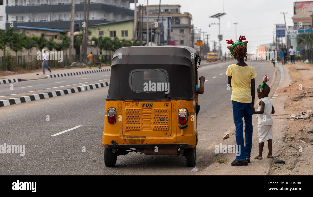 Persone che celebrano il Natale natalizio in un affollato mercato di strada a Lagos, Stato di Lagos, Nigeria. Acquirenti, venditori e pedoni si riuniscono. Foto Stock