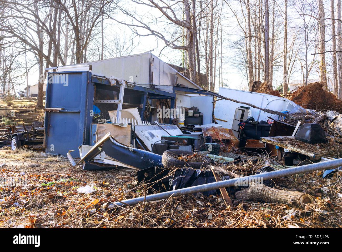 Raccolta di articoli scartati un rimorchio rovesciato è sparso intorno agli alberi nelle zone rurali Foto Stock