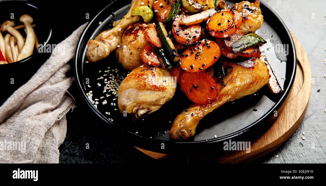 Ali di pollo con glassa dolce e salata servita con riso e funghi su sfondo scuro. Vista dall'alto. Foto Stock