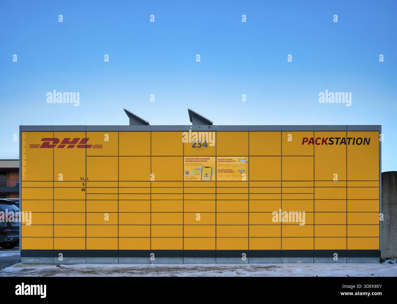 Stazione di imballaggio DHL, logo, giallo, con celle solari, pannelli solari per la fornitura di energia solare, cielo, blu, Stoccarda, Baden-Wuerttemberg, Germania Foto Stock