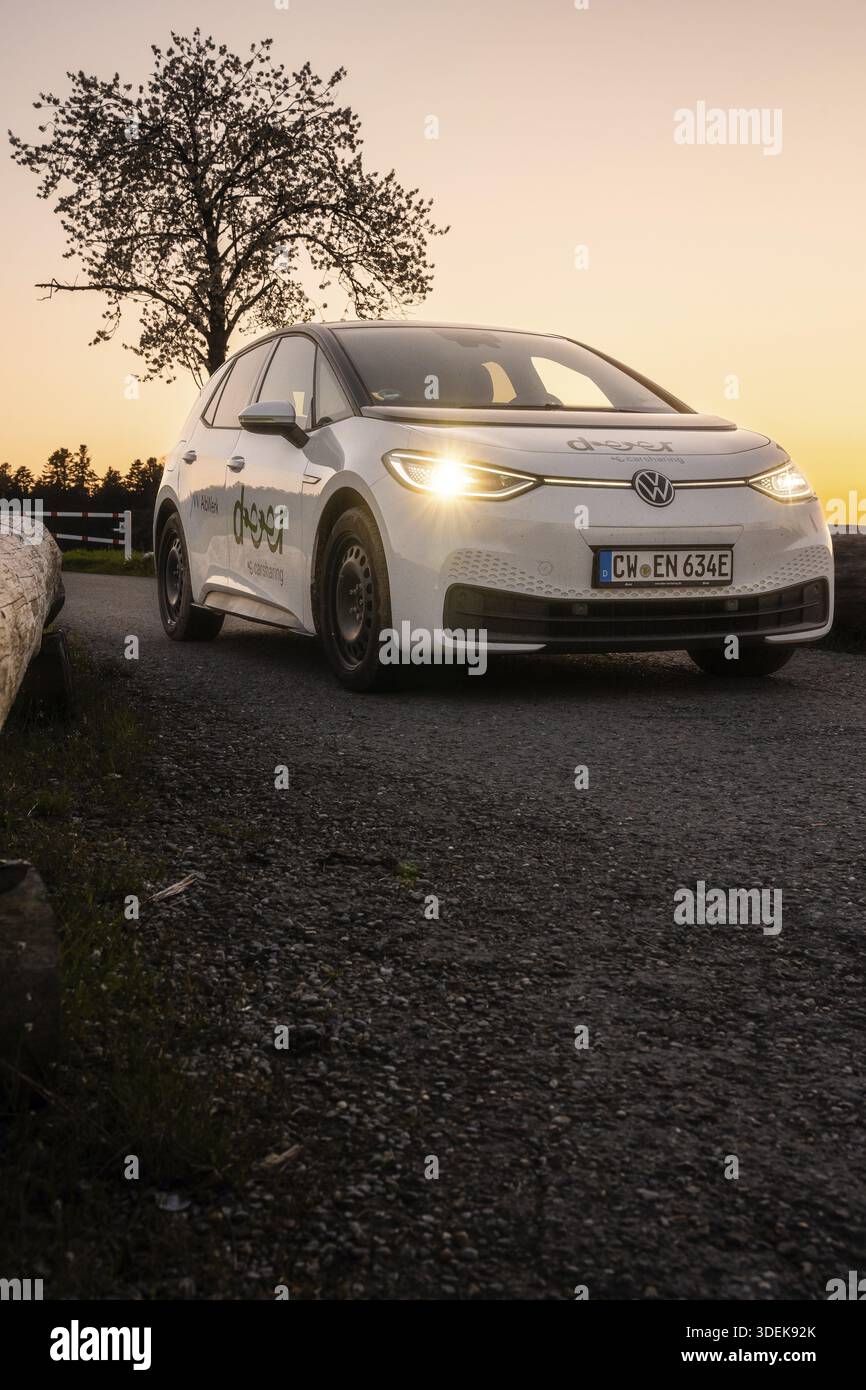 Auto che percorre una strada con fari accesi la sera, auto elettrica VW ID3, Deer e-Carsharing, Calw, Germania Foto Stock