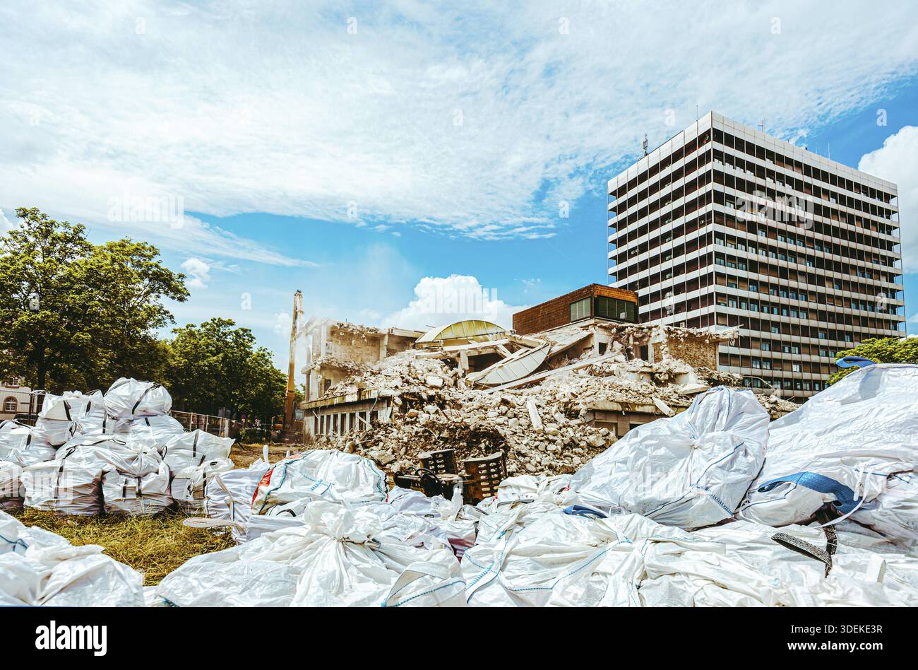 Processo di demolizione di un vecchio edificio smantellato. L'escavatore sta distruggendo la vecchia casa. Distruzione di abitazioni fatiscenti per un nuovo sviluppo. Demolizione di Foto Stock
