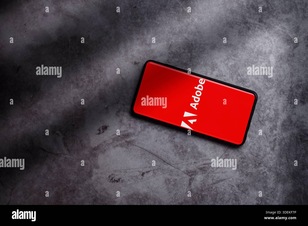 Foto piatta dello smartphone che visualizza il logo Adobe sullo schermo. Adobe Creative computer software Company. Foto Stock