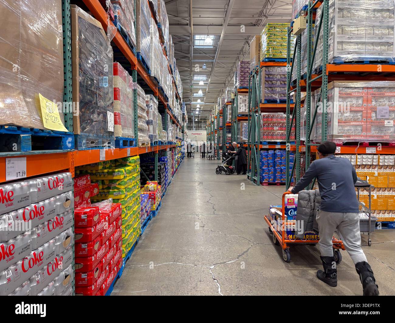 Interni del club del magazzino Costco. Cliente maschio che spinge il carrello. Acquisti in blocco, vendita all'ingrosso, vendita al dettaglio, spesa al consumo, economia, la vita di tutti i giorni. Foto Stock