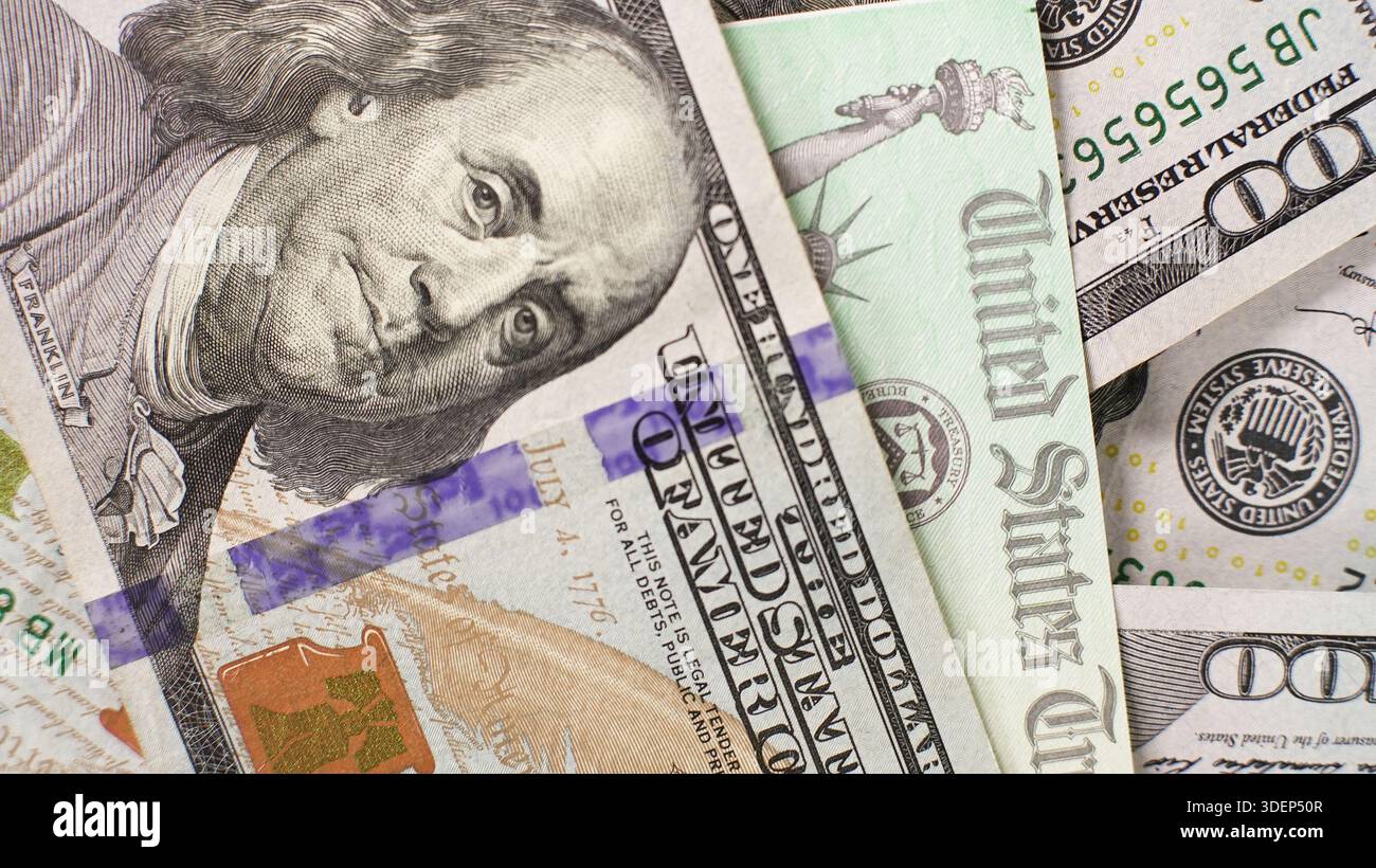 Vista ravvicinata della valuta degli Stati Uniti con il rimborso delle imposte sugli assegni del Tesoro degli Stati Uniti. L'attenzione è sulla banconota da cento dollari insieme ad altri in un mix Foto Stock