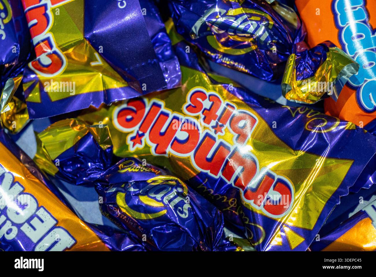 Cadburys cioccolatini dolci in involucri da vicino, astratto di involtini dolci con vari nomi, crunchie, giravolte, cioccolato a due piani. Foto Stock