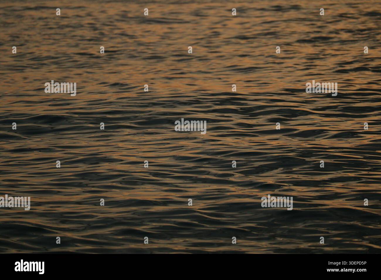 Colata d'acqua dell'oceano con colori al tramonto Foto Stock