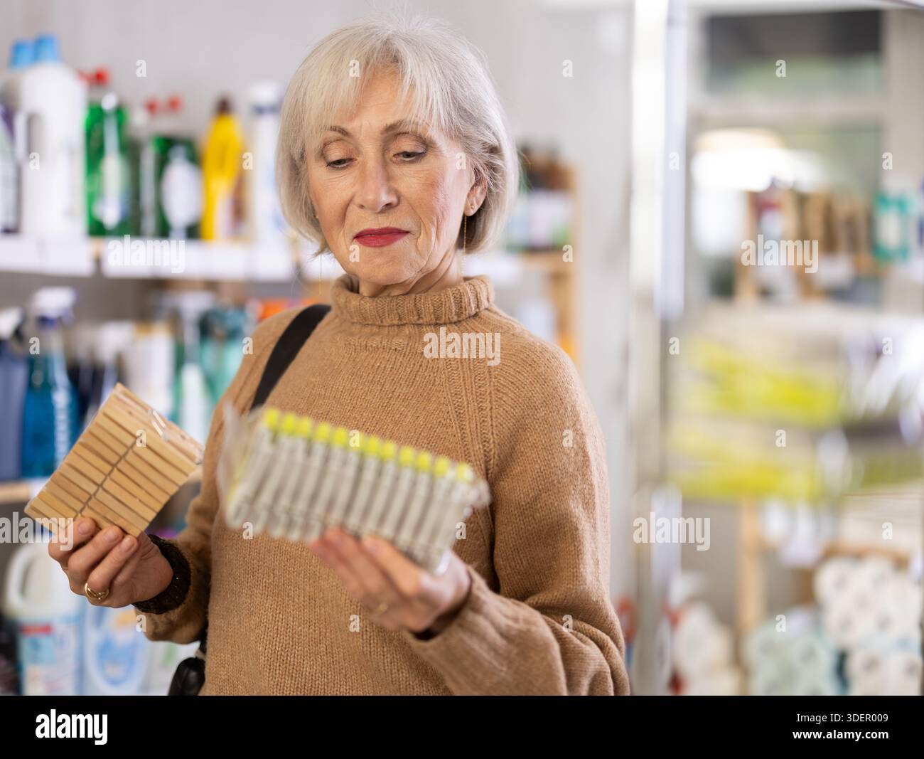Donna che sceglie un set di clothespins nel negozio Foto Stock