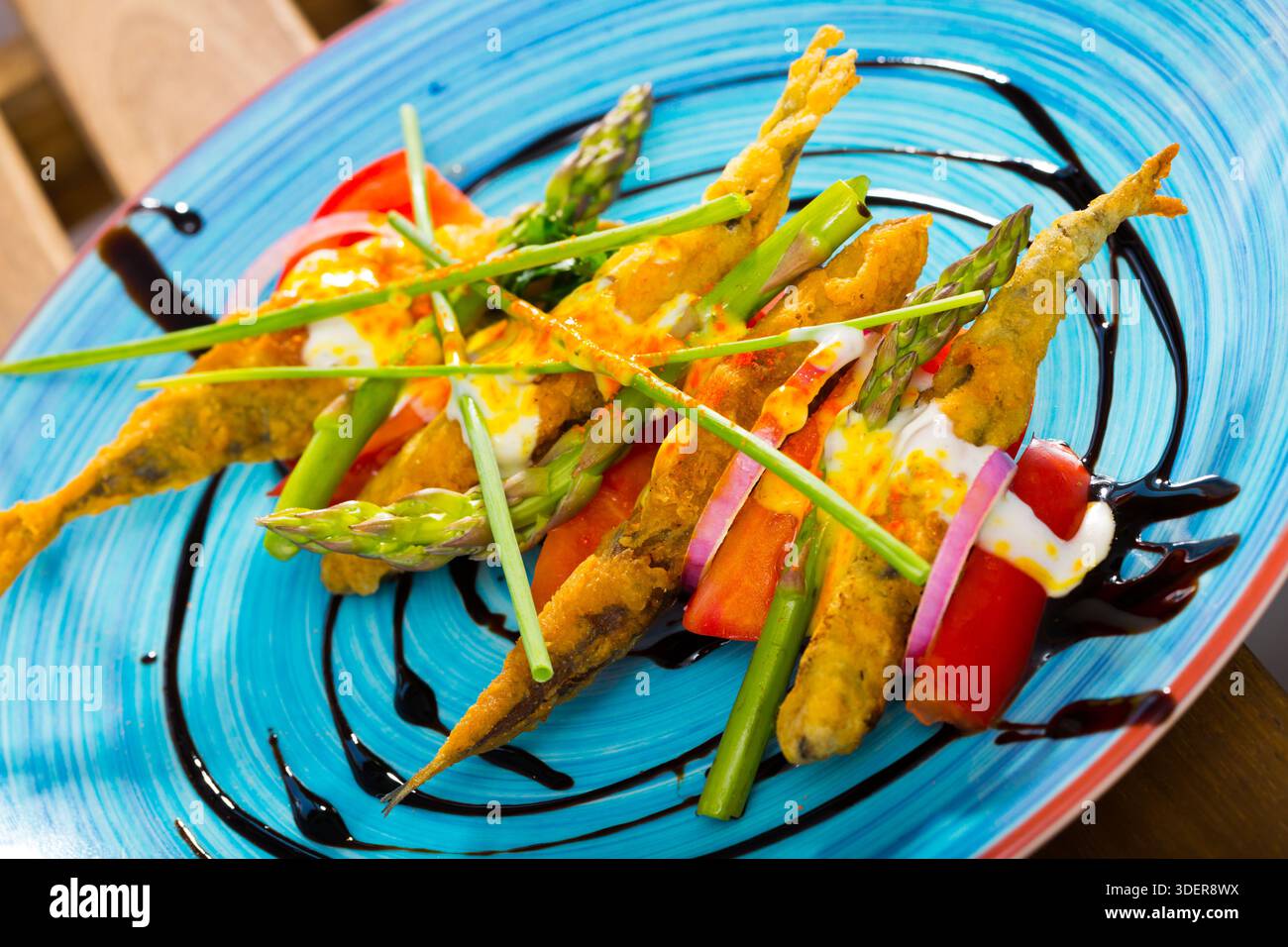 Spratti fritti con salsa cremosa allo zenzero, pomodori, aceto balsamico Foto Stock
