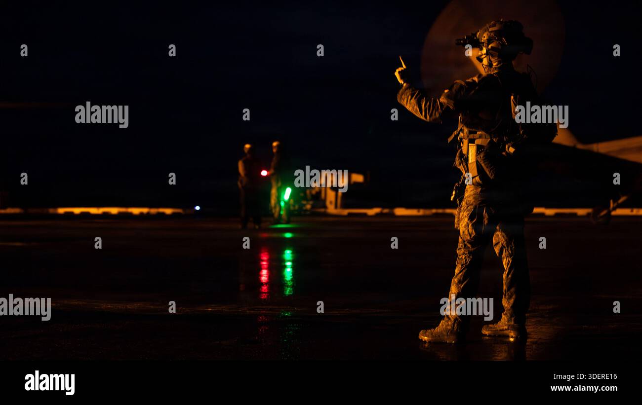 Un Marine degli Stati Uniti segnala ad altri membri del team sulla piattaforma di volo della più grande portaerei del mondo, la portaerei classe Ford USS Gerald R. Ford (CVN 78) prima di un diritto di imbarco durante la visita nell'Oceano Atlantico, 7 gennaio 2026. Le forze militari degli Stati Uniti sono schierate nell'area delle operazioni del Southern Command a sostegno della missione del Southern Command, delle operazioni dirette dal Dipartimento della Guerra e delle priorità del presidente di interrompere il traffico illecito di droga e proteggere la patria. (Foto della Marina degli Stati Uniti) Foto Stock