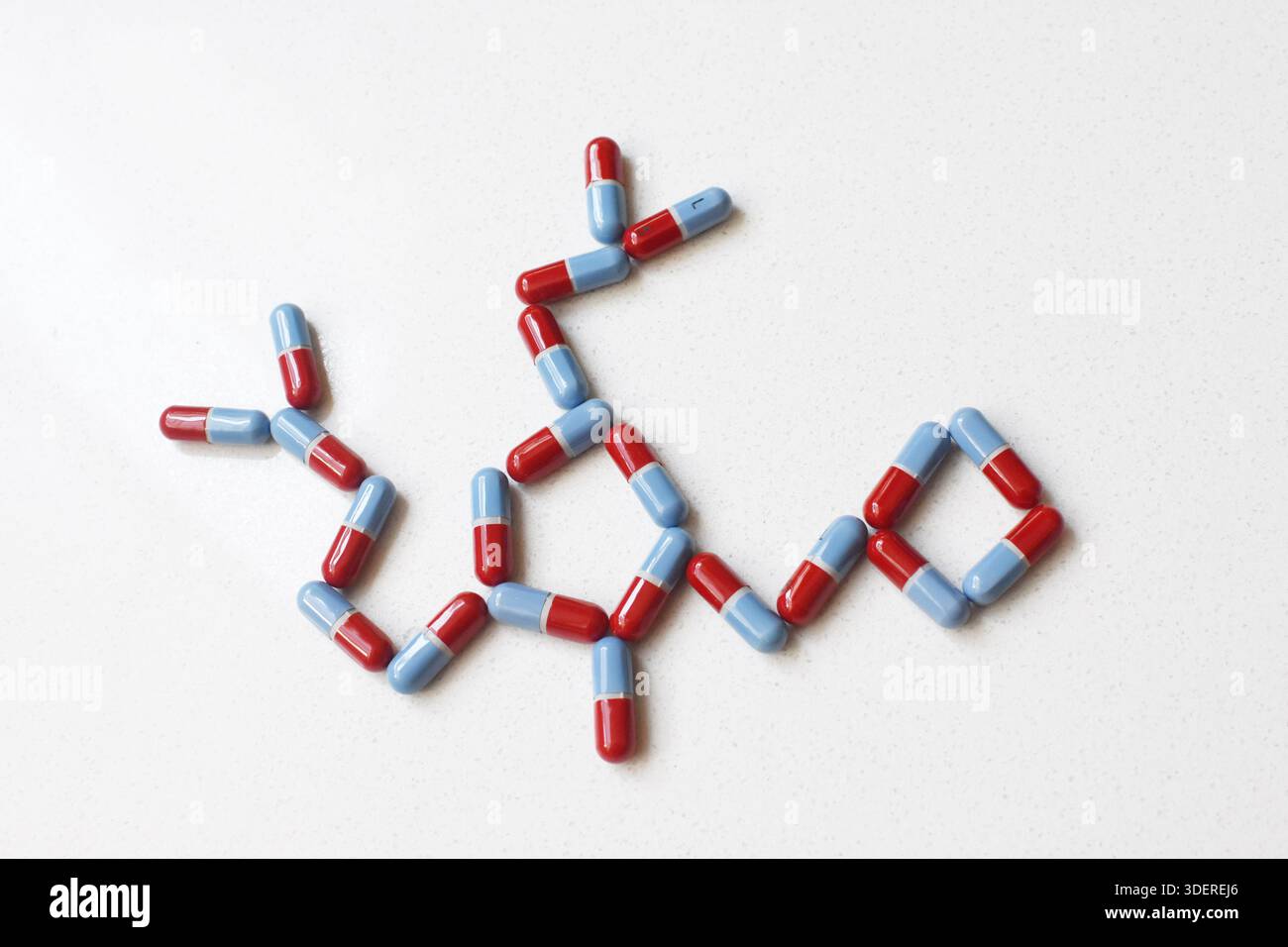Pillole disposte formando una forma di DNA su un tavolo bianco, vista dall'alto piatto, concetto medico e scientifico che combina sanità, genetica e farmacia. Foto Stock