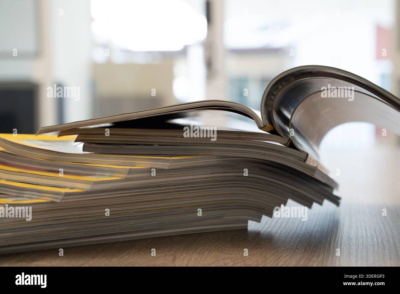 Primo piano di caricatori aperti impilati che mostrano pagine curve e sfondo sfocato. Editoria, giornalismo e stampa con spazio per il testo. Foto Stock