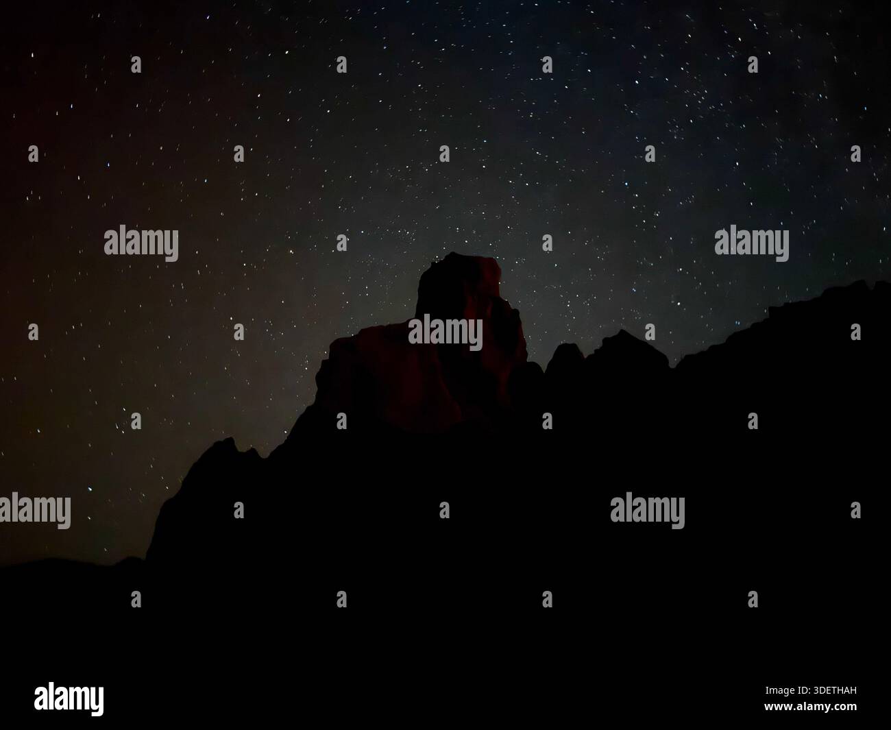 Silhouette scura di formazioni vulcaniche sotto un cielo pieno di stelle nel Parco Nazionale del Teide, Tenerife, catturata di notte. Foto Stock