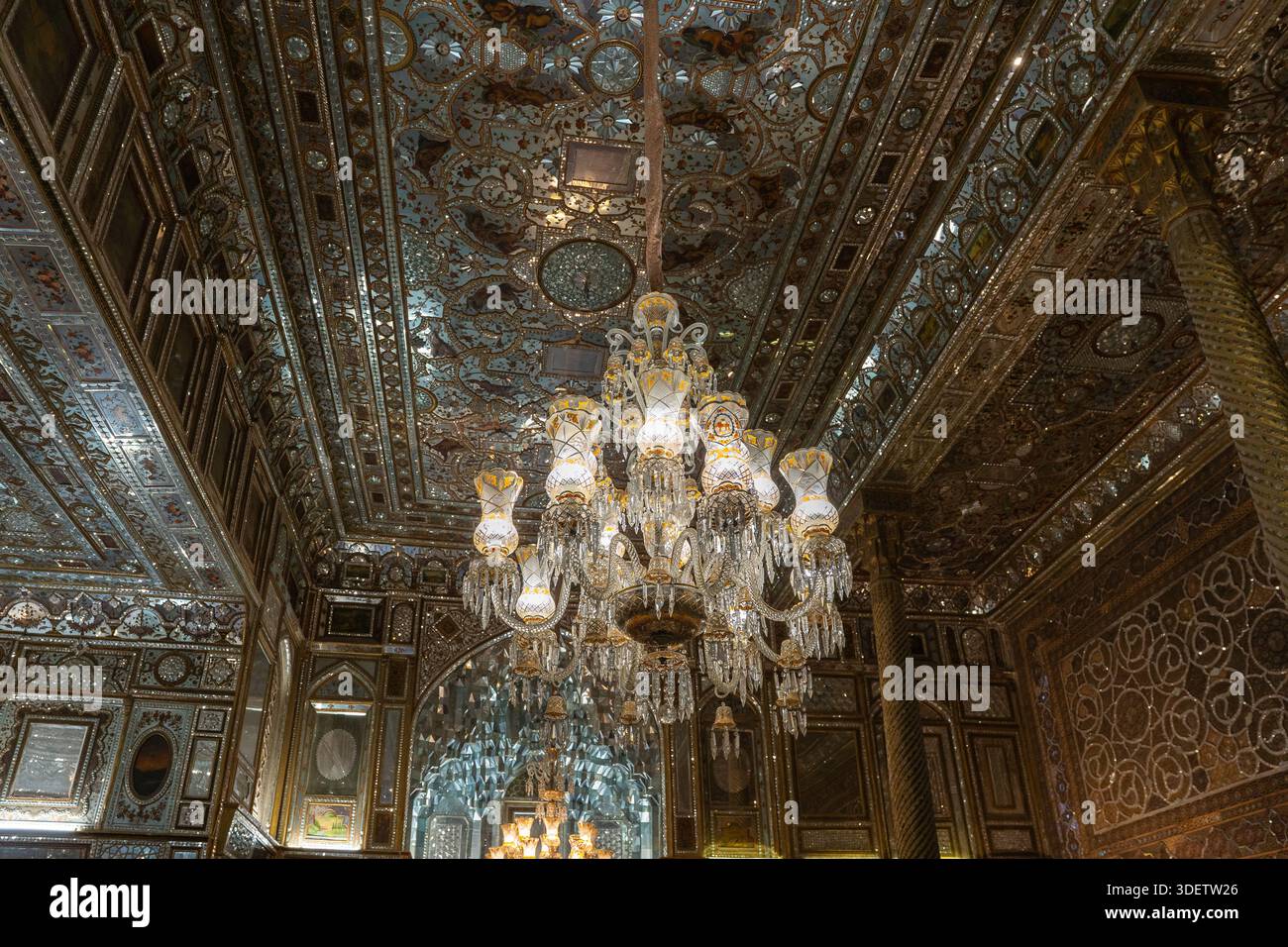 Grande lampadario di cristallo contro intricati interni in mosaico a specchio persiano Foto Stock