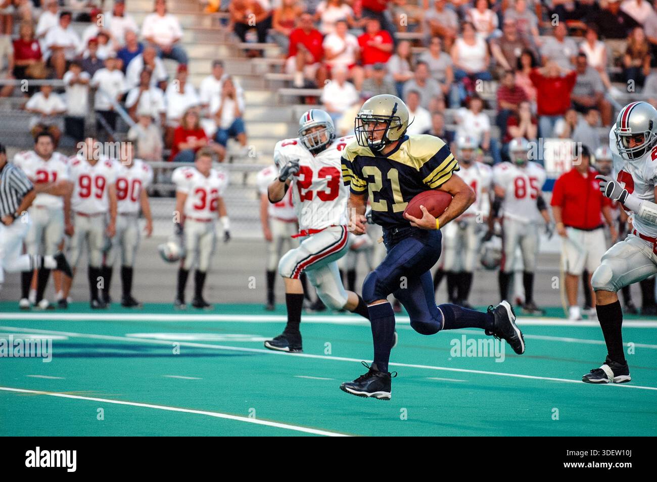 Inseguito dagli avversari del Muhlenburg College, il running back del TCNJ Cory Schoonover fa un salto nel campo durante una partita di calcio mentre i tifosi dei Mules lo fanno Foto Stock