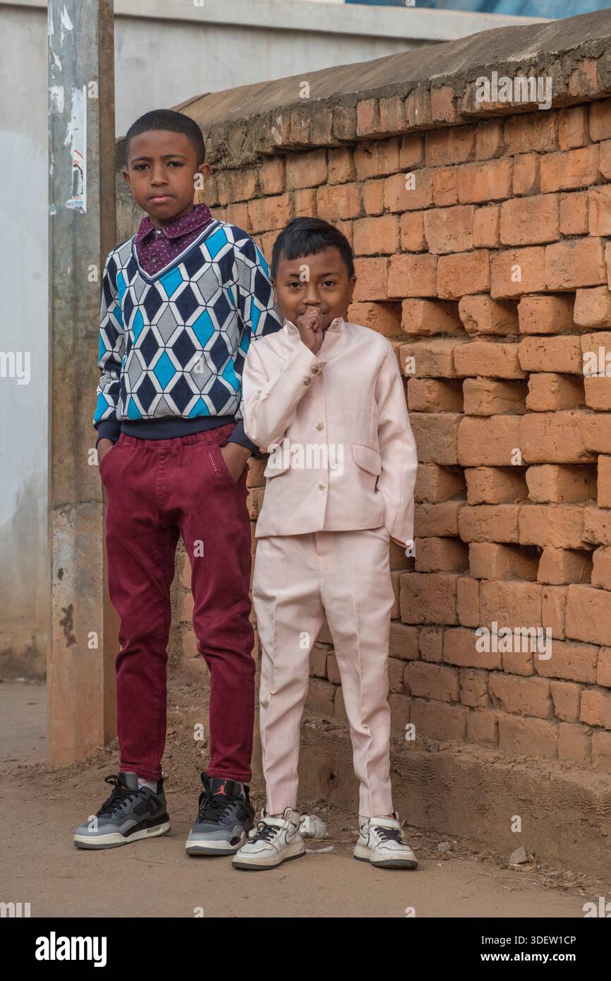 Ritratto di due bambini malgasci domenica mattina, Ambositra, Madagascar. Per molte famiglie degli altipiani centrali del Madagascar, dove il cristianesimo è la religione di maggioranza, partecipare a una funzione ecclesiastica è un importante evento settimanale e una parte fondamentale della loro vita culturale e sociale. I bambini sono spesso vestiti al meglio della domenica, riflettendo il rispetto per l'occasione e l'orgoglio della loro comunità. Ambositra, Madagascar. Foto Stock