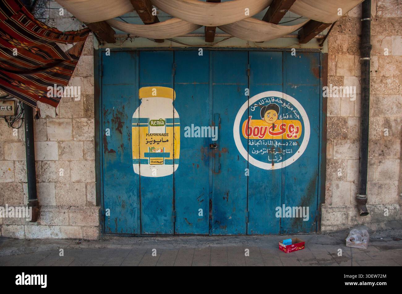 Pubblicità dipinte in un negozio chiuso a Baalbek, Libano Foto Stock