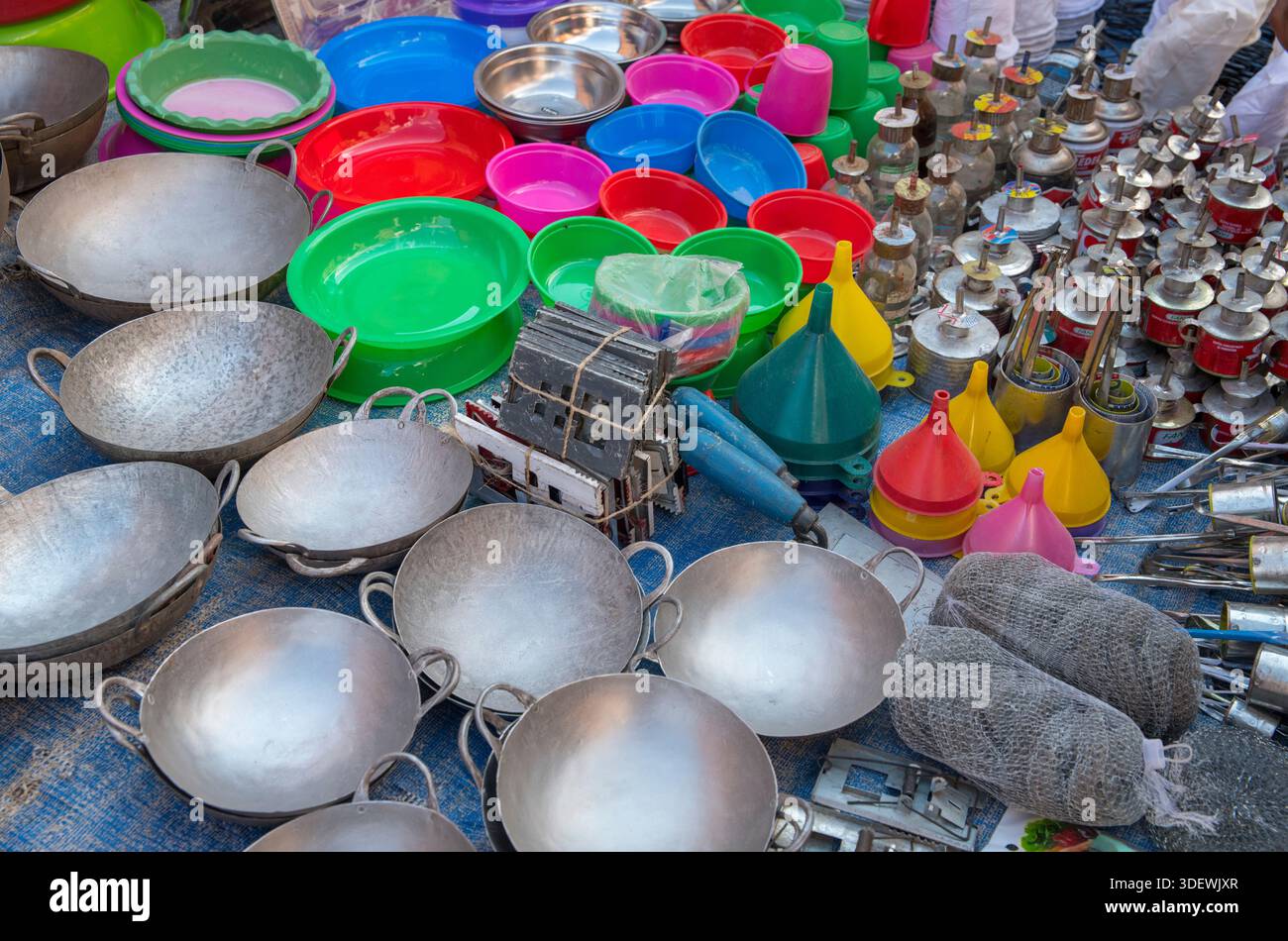 Articoli di tutti i giorni in vendita da una bancarella presso il principale mercato di Anjoma a Fianarantsoa - un vivace fulcro della vita quotidiana e del commercio nel cuore degli altopiani centrali del Madagascar. Il mercato è noto per la sua vasta gamma di prodotti locali, prodotti artigianali e l'atmosfera vivace. Padelle, ciotole di plastica, bruciatori a olio. Foto Stock