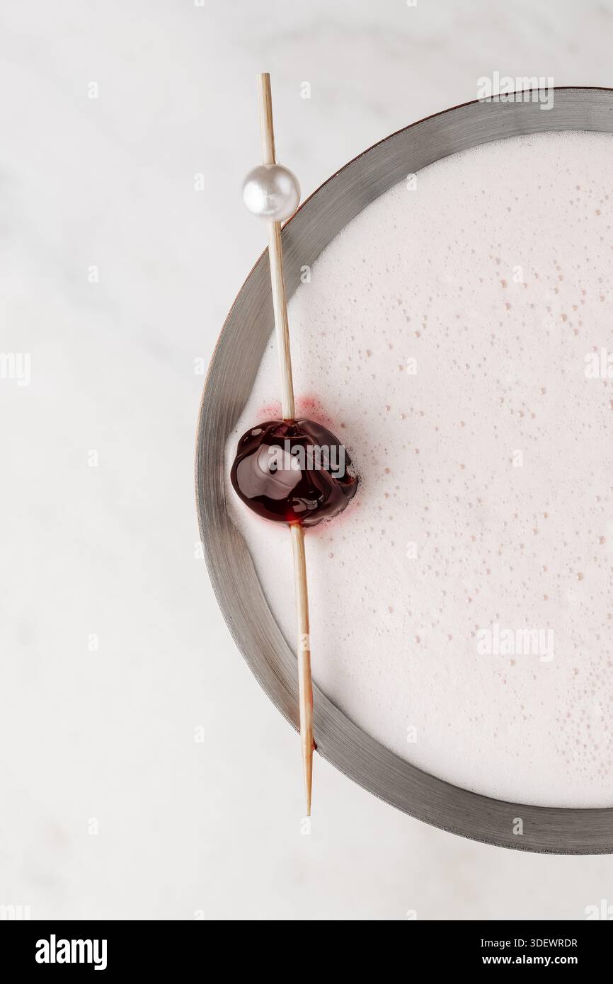 Primo piano di un elegante martini lychee in un classico bicchiere martini, decorato con un litchi fresco, che mette in risalto il cocktail chiaro e la delicata consistenza Foto Stock