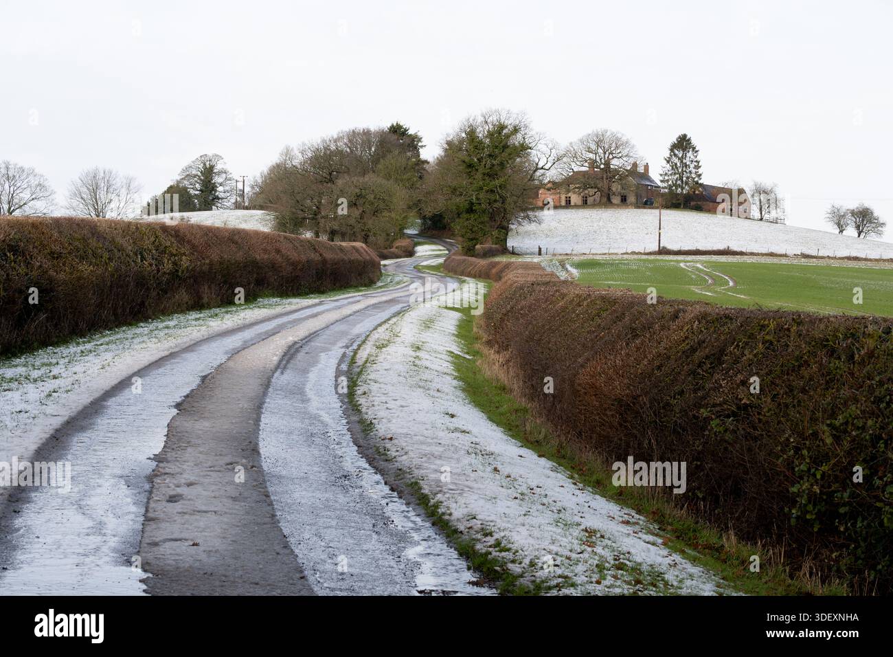 Una strada di campagna in inverno con neve, Warwickshire, Inghilterra, Regno Unito Foto Stock