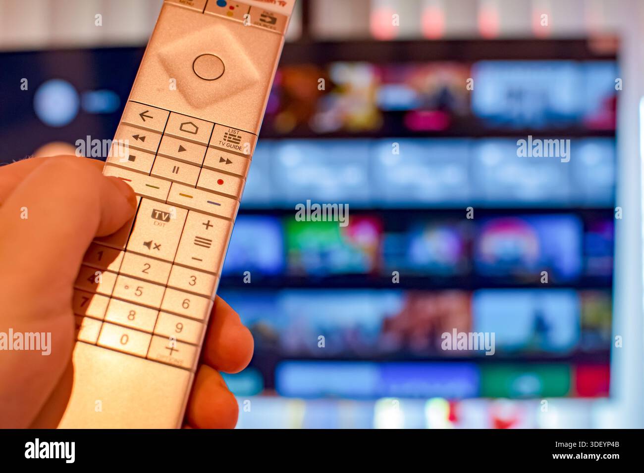 Dotato di telecomando per la tv rivolto verso un grande schermo piatto 4k Foto Stock