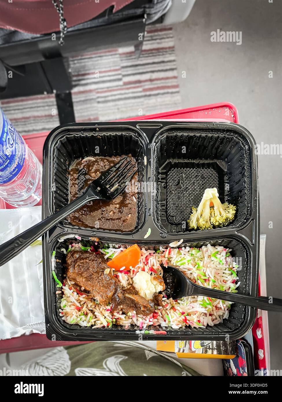 Pasto in treno ETS con riso, verdure e carne servito in un vassoio di plastica nero su un vassoio in stile aereo carrello di prima classe KTMB malaysia Foto Stock