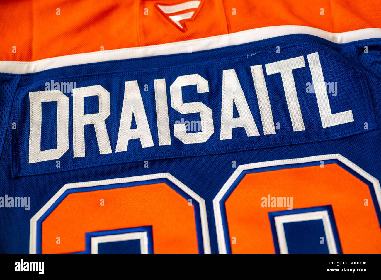 Calgary, Alberta - 31 dicembre 2025: Maglione da hockey blu e arancione degli Edmonton Oilers, con nome e numero di Leon Draisaitl. Foto Stock
