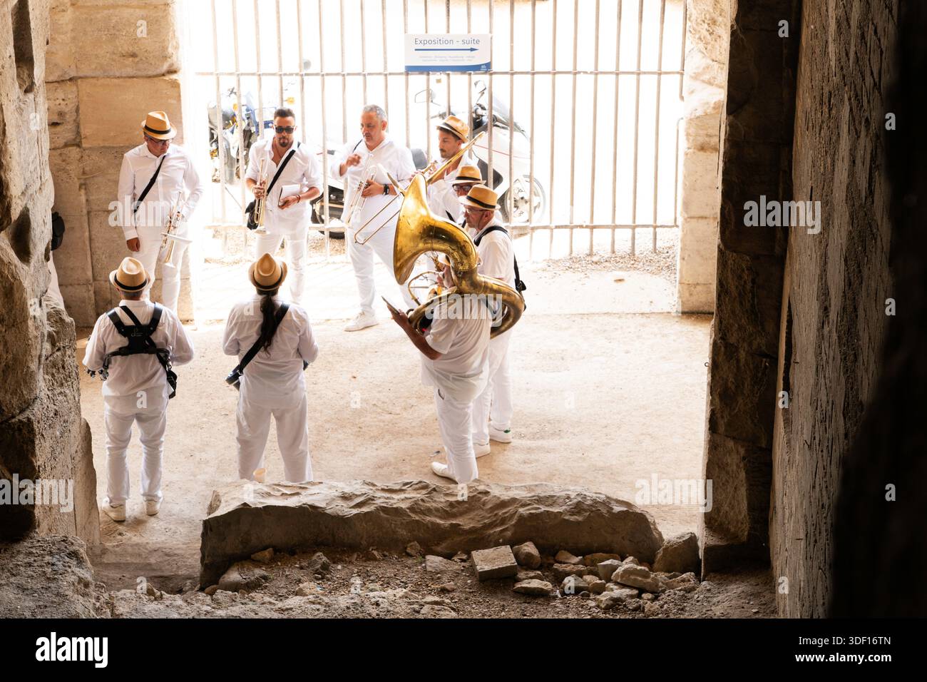 Un gruppo di musicisti maschili suona nell'antica Arena romana prima dell'inizio della corsa dei tori del corso la Cocarde, Arles, Provenza, Francia, Europa Foto Stock