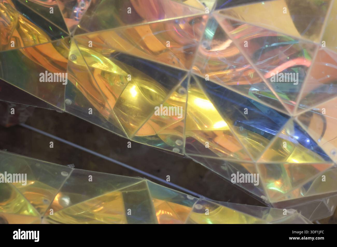 Le sfaccettature a specchio astratte in oro lucido riflettono la luce colorata creano un vivace motivo geometrico con una brillante texture di cristallo che mostra emozioni da sogno Foto Stock