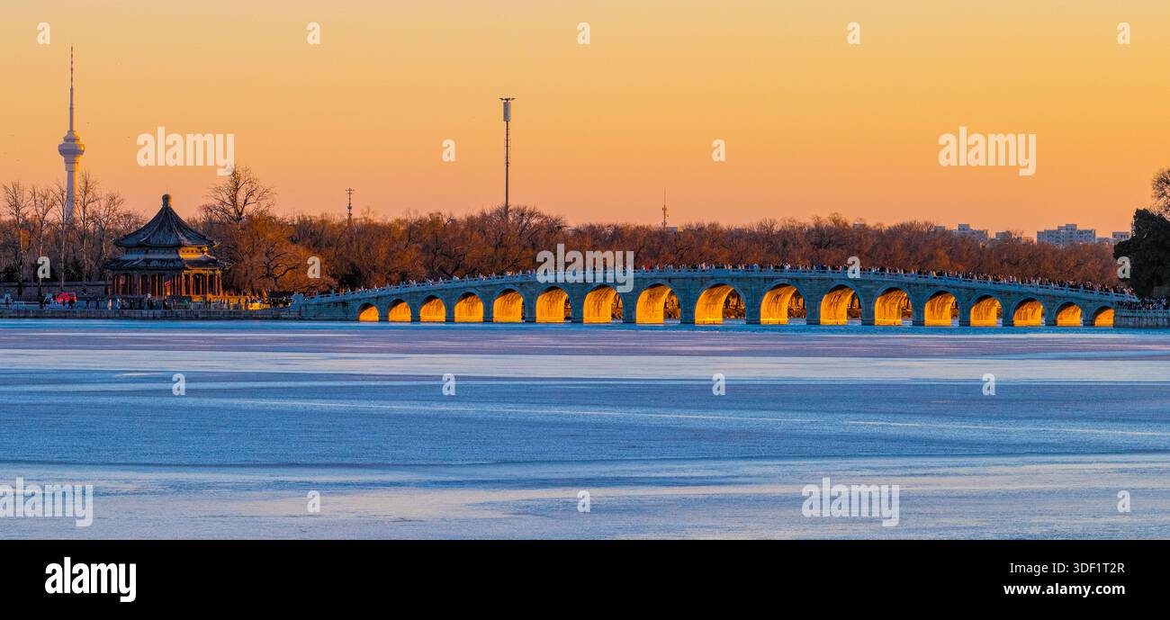 Il bellissimo paesaggio del Palazzo d'Estate di Pechino mentre il sole tramonta sul Ponte del diciassettesimo arco in inverno. Foto Stock