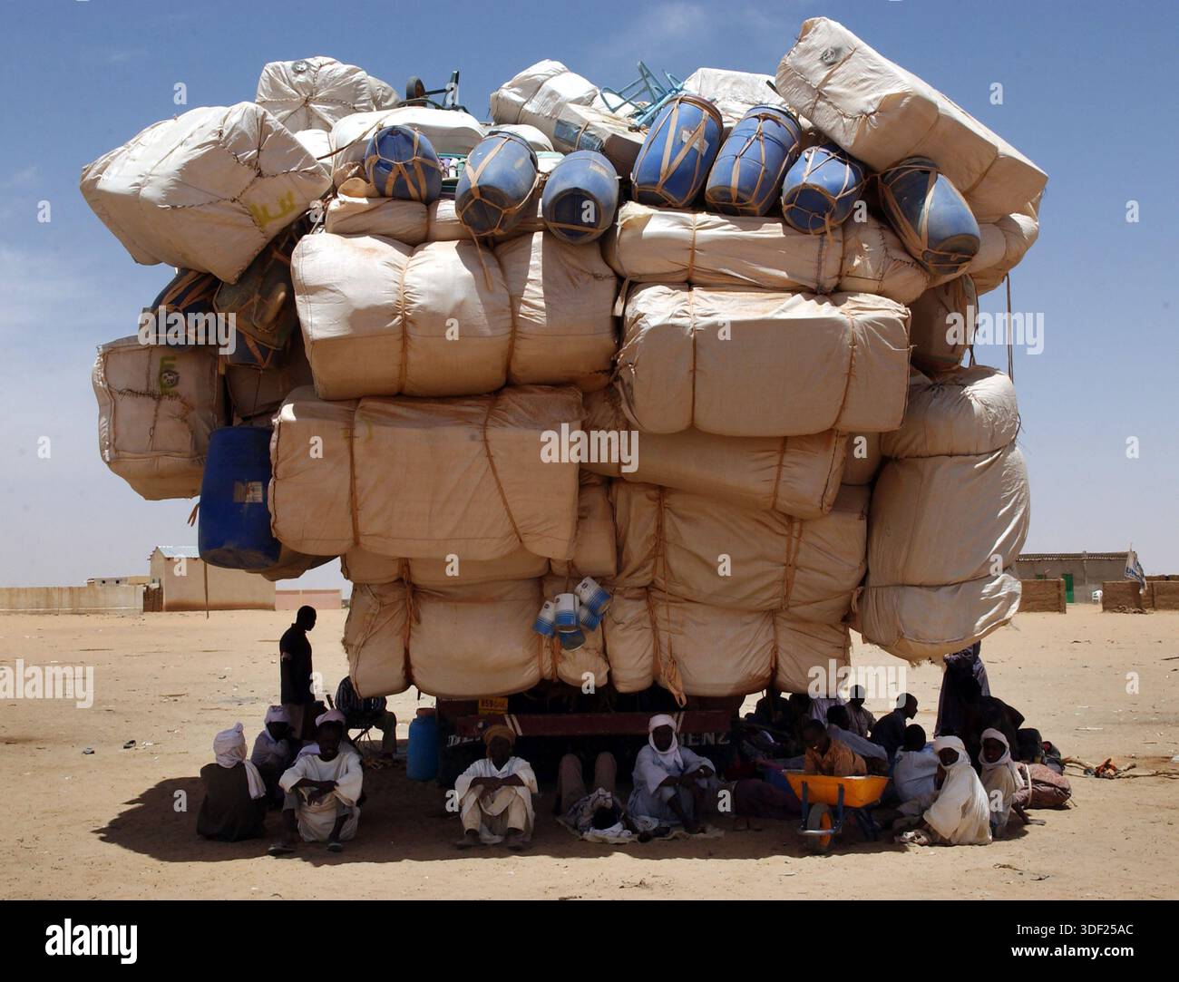 10/06/04, SCOTSMAN, TSPL, NOTIZIE, TRASPORTI,. STRANIERO,. CARESTIA E SICCITÀ,. AFRICA,. RIFUGIATI IRIDIMI, CIAD, AFRICA. I LAVORATORI SI RIFUGIANO DAL SOLE DI MEZZOGIORNO SOTTO UN CAMION DIRETTO IN TUNISIA A BAHAI, AL CONFINE CIADIANO-SUDANESE. PIC IAN RUTHERFORD Foto Stock