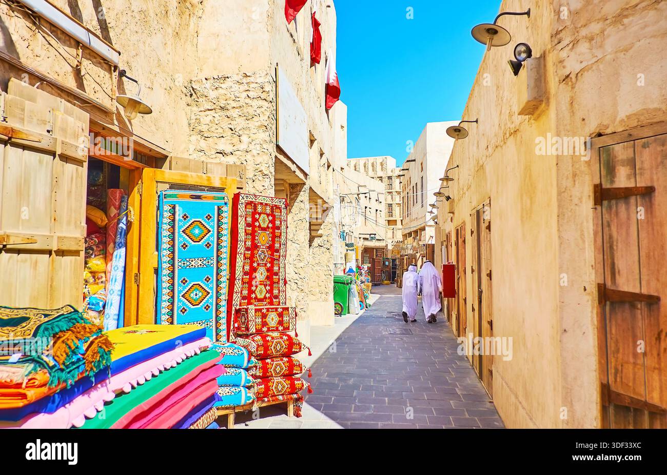 DOHA, Qatar - 13 febbraio 2018: i tappeti colorati, cuscini e tessuti in negozio, situato nella vecchia strada stretta di Souq Waqif - centro città di mercato Foto Stock
