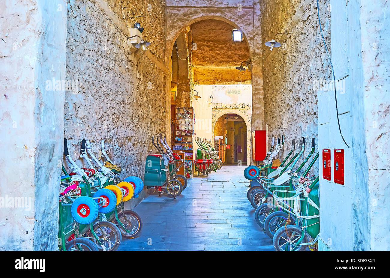 Lo stretto corridoio ombreggiato nel Souq Waqif è utilizzato dai portatori per tenere le carriole, Doha, Qatar Foto Stock
