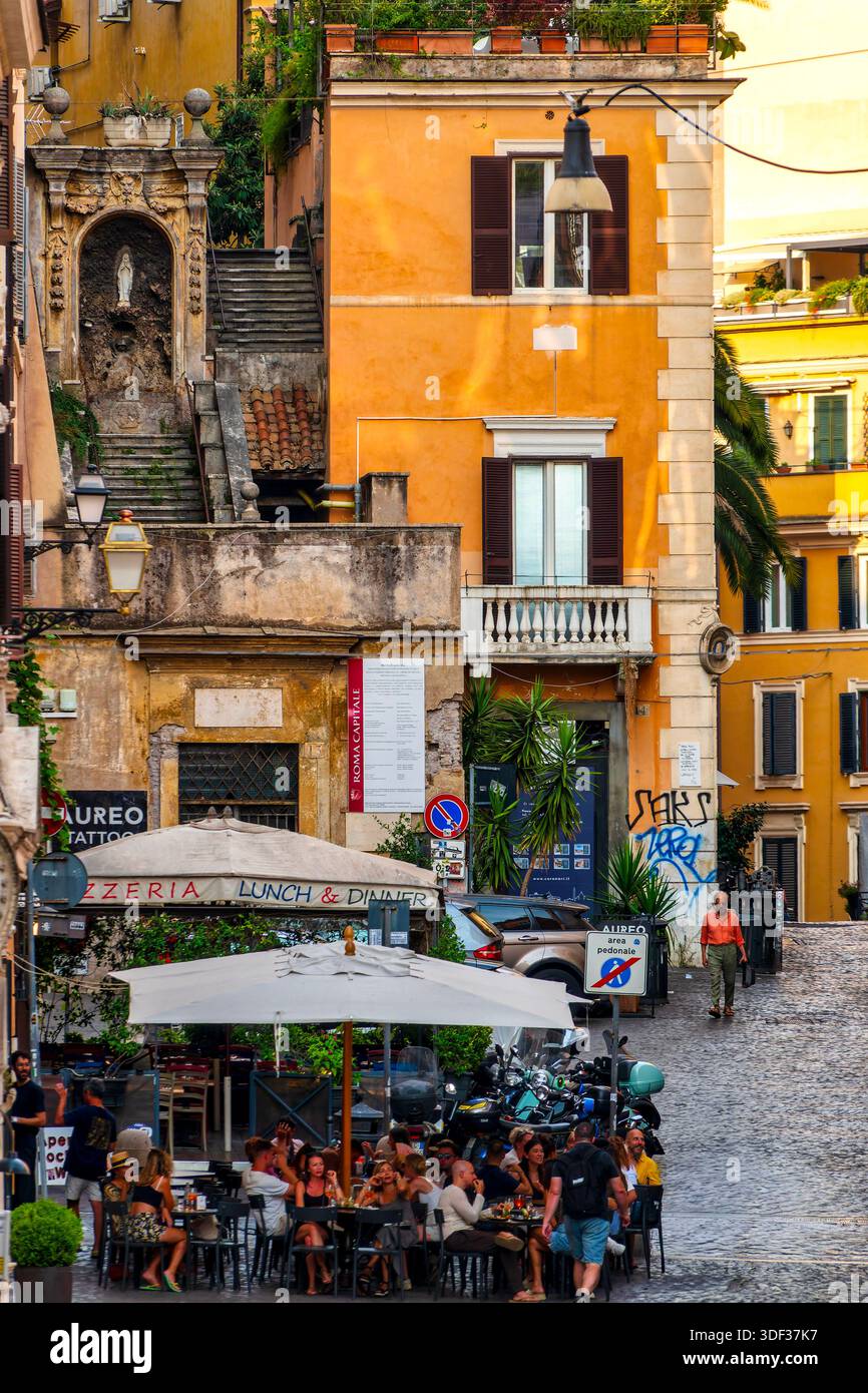 Vista su via degli Zingari nel quartiere Monti di Roma, con ristoranti e un santuario sopra i gradini. Italia. Foto Stock