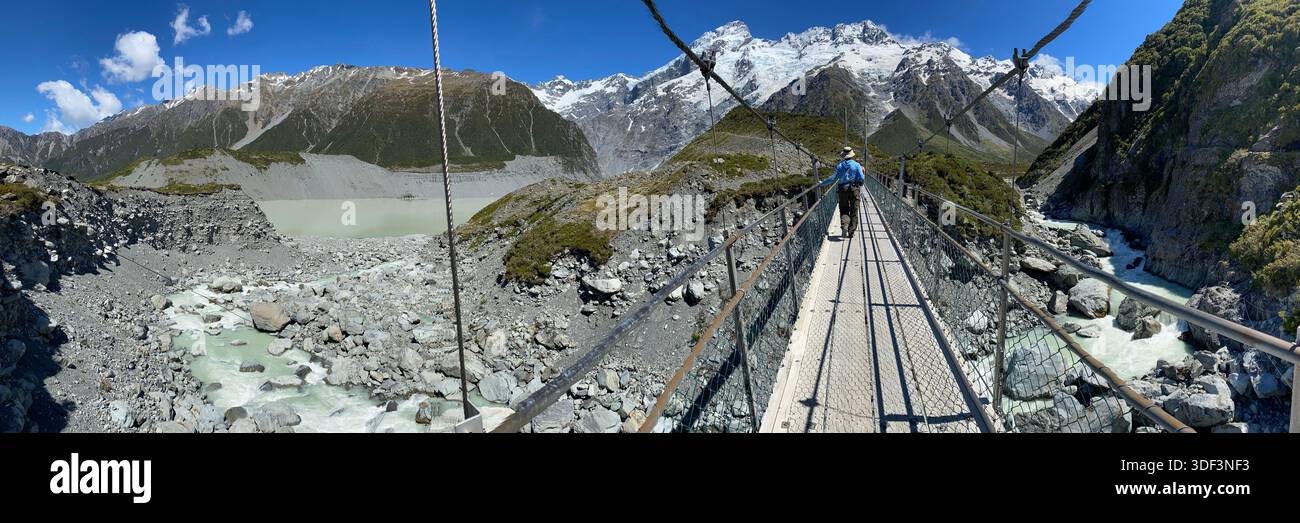 Un escursionista attraversa il terzo ponte sul sentiero Hooker Valley nel monte Parco nazionale Cook/Aoraki. Foto di Marilynn Mastroianni. Foto Stock