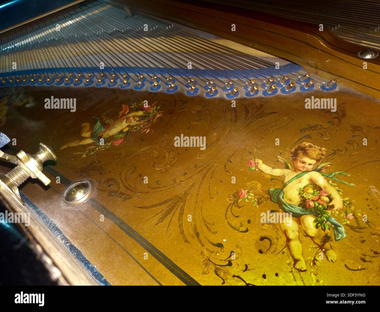 Antico piano Baby Grand con dettagli Cherubs e blu dipinti a mano, dettagli interni con coperchio aperto Foto Stock