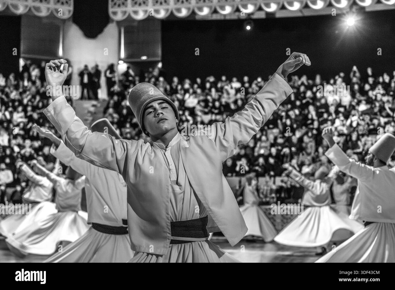 La cerimonia Şeb-i Arus al Mevlana Kültür Merkezi a Karatay, Konya, Turchia, un luogo che può ospitare 3.000 persone, mostra dei dervisci durante la danza rituale Sema. La mano destra punta verso l'alto, ricevendo la benedizione di Dio. La mano sinistra punta verso il basso, passandola alla terra. I dervisci girano in senso antiorario, simbolicamente contro l'ego. Il piede destro rimane fisso mentre il piede sinistro guida la rotazione. Şeb-i Arus è la festa annuale che segna l'anniversario della morte (17 dicembre) del poeta mistico Rumi (Jalāl ad-Dīn ar-Rūmī, 1207–1273), fondatore dell'ordine Mevlevi, celebrato come Foto Stock