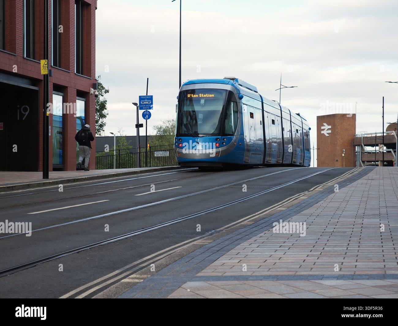 Un tram in Railway Drive, Wolverhampton, tra gli edifici i9 e i10, sulla strada per la stazione ferroviaria di Wolverhampton da Birmingham a ottobre 2025 Foto Stock
