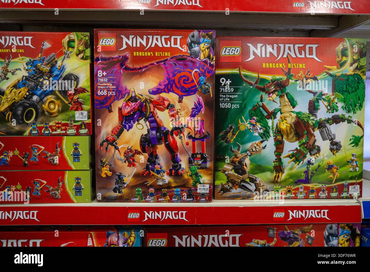 Set di edifici LEGO Ninjago Dragons Rising esposti su uno scaffale di un negozio di giocattoli, con kit di costruzione a tema drago e ninja in vendita. Foto Stock