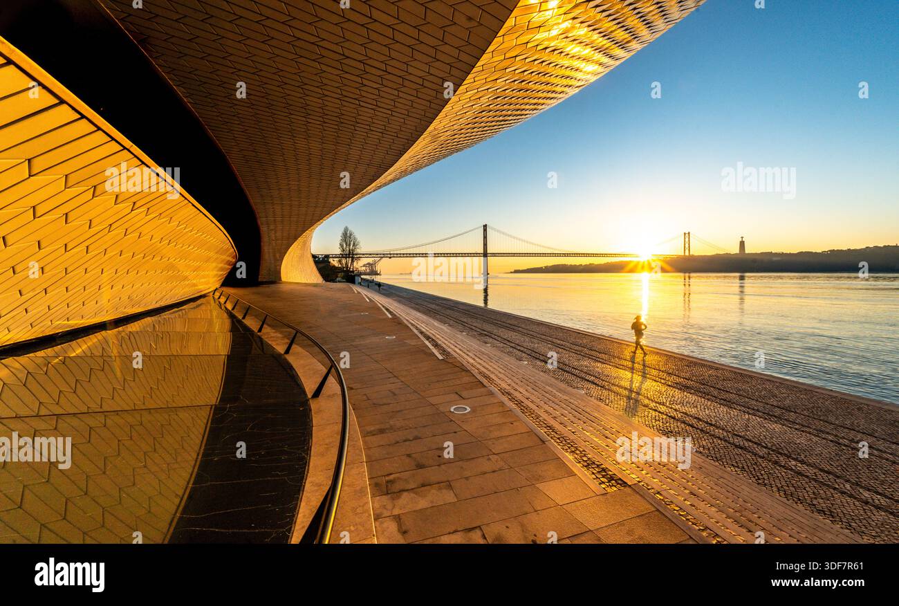Museo MAAT Lissabon mit geschwungener Fassade und Jogger bei Sonnenaufgang, Tejo Lissabon Belem Portogallo. Architettura moderna Foto Stock