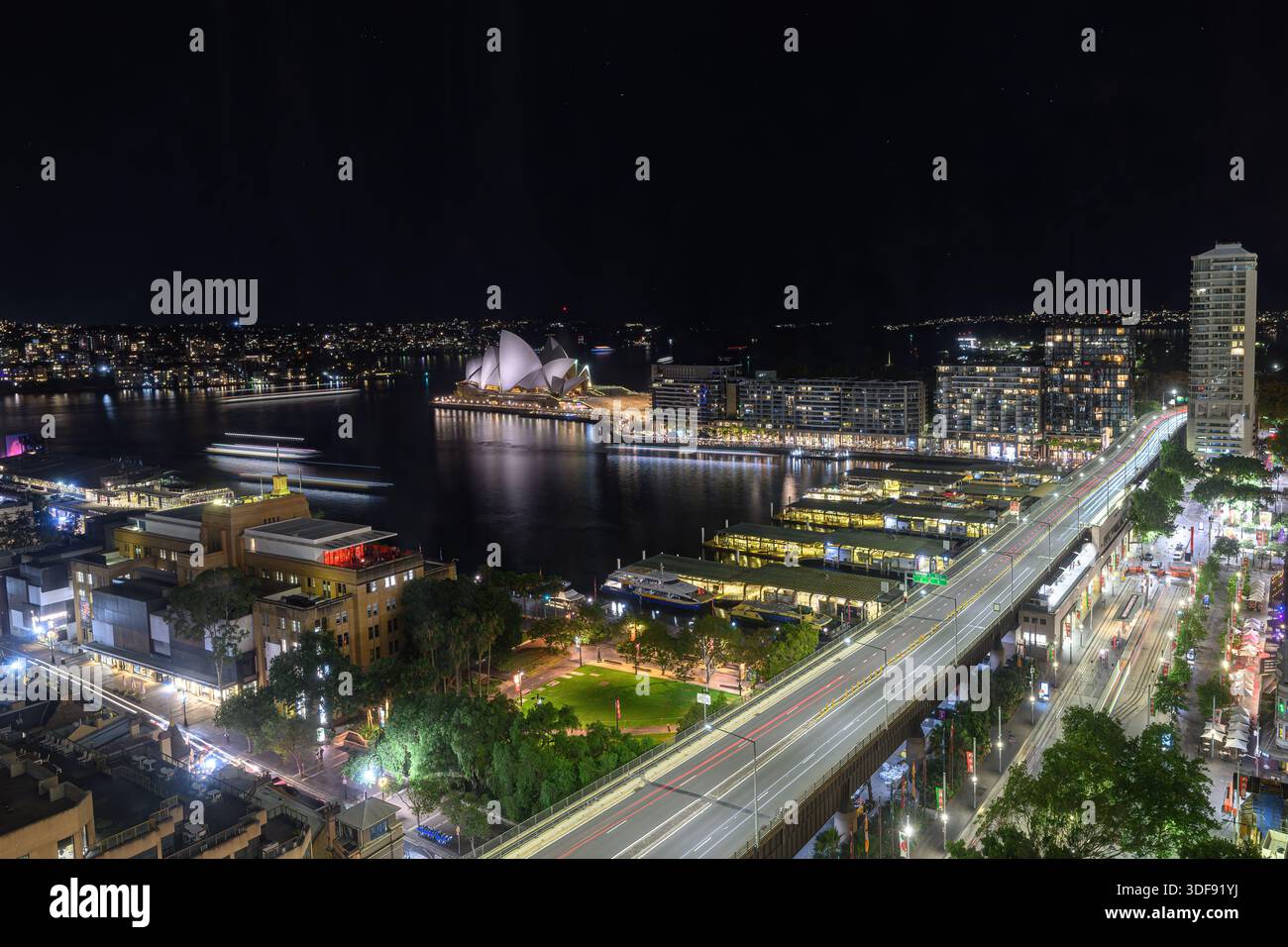 Un'esposizione temporale del porto di Circular Quay di notte. Sydney, Australia. Le luci dei traghetti e dei veicoli sembrano striature dovute all'esposizione temporale. Foto Stock