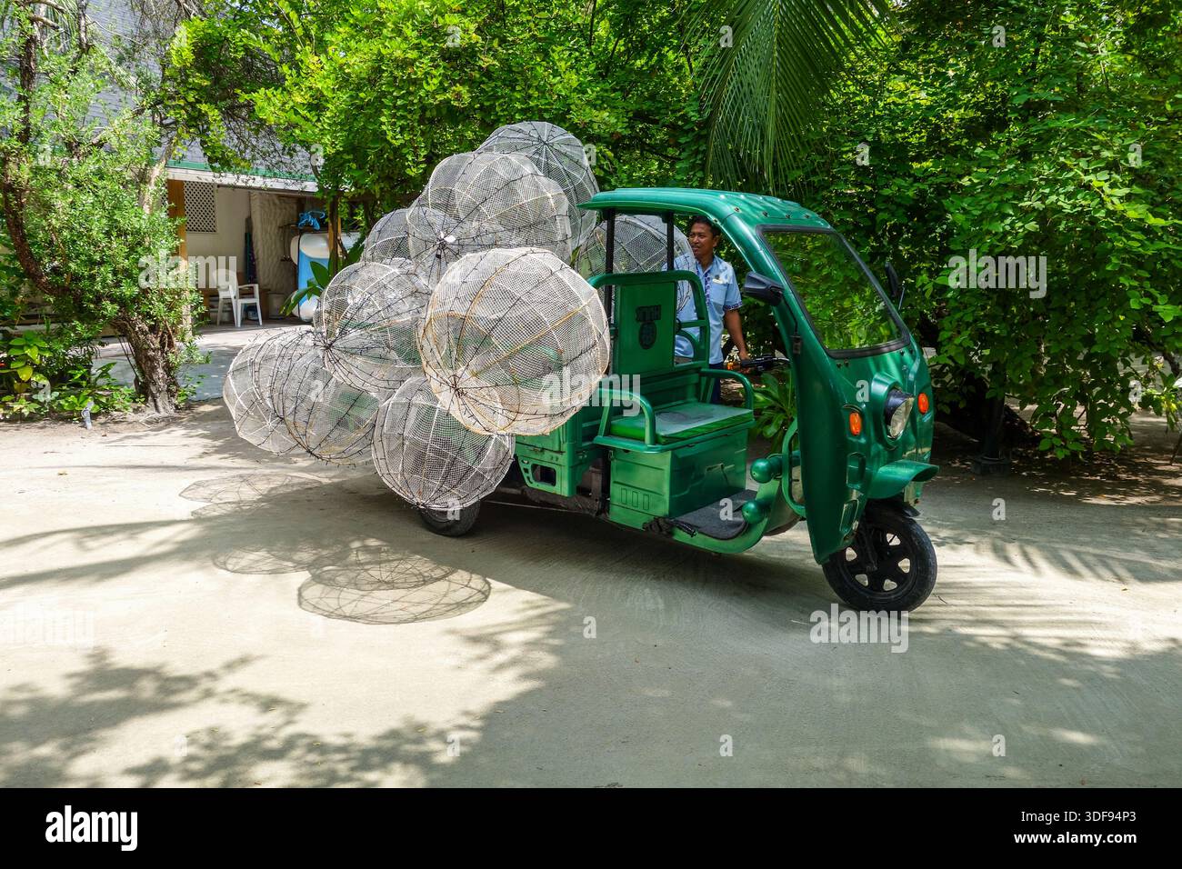 Un veicolo a 3 ruote che trasporta luci a globo presso il resort di vacanza Cinnamon Dhonveli, Malé, Maldive, Oceano Indiano, Asia Foto Stock