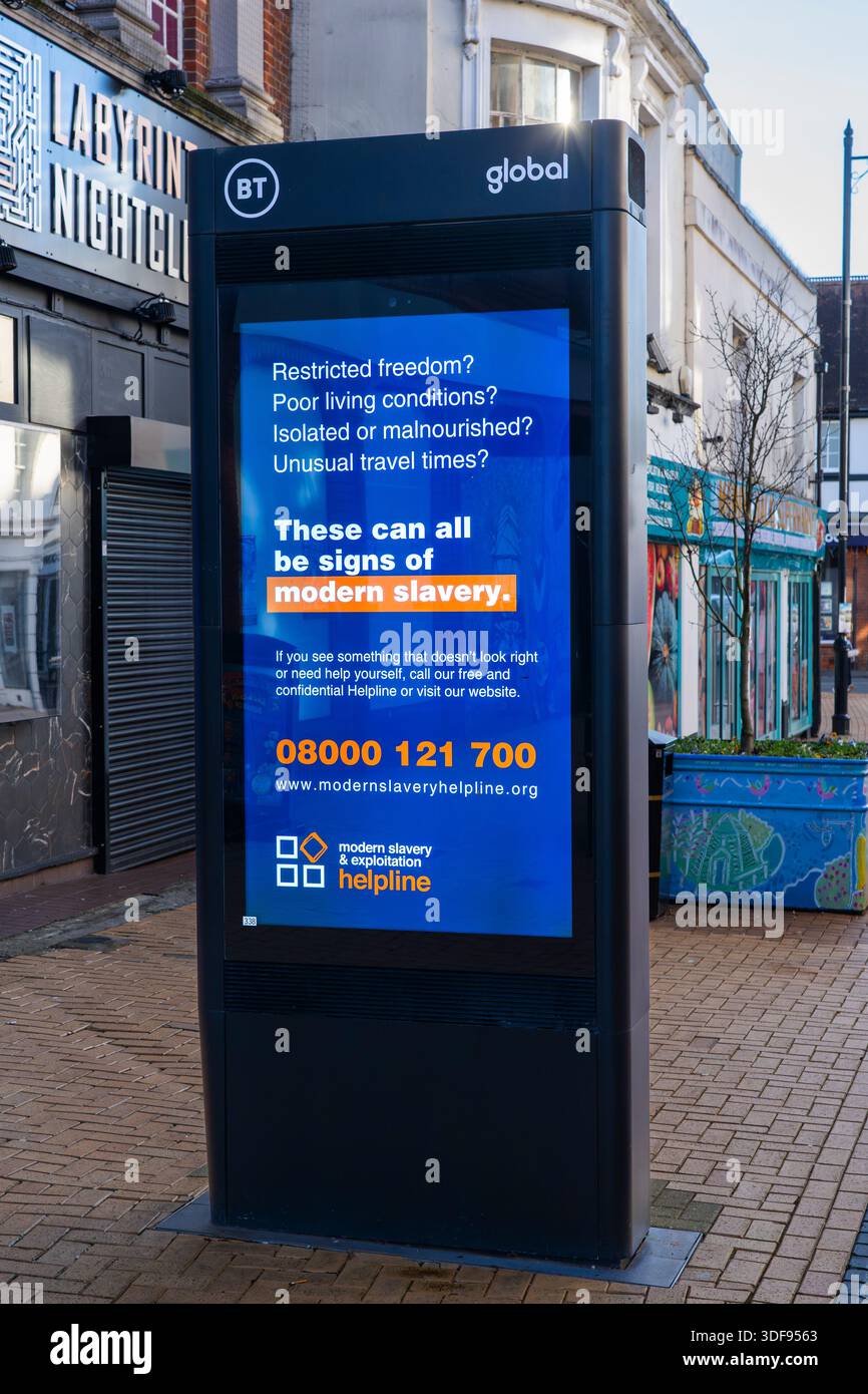 BT Global Street Hub su Winchester Street pubblicizza una linea di assistenza per la schiavitù moderna e mostra segnali di avvertimento come libertà limitata. Basingstoke, Regno Unito Foto Stock