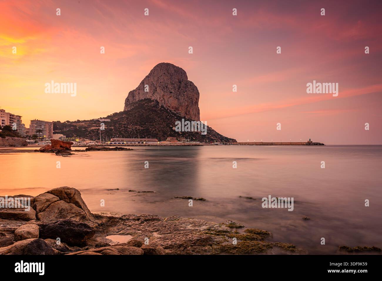 L'alba dorata dipinge il cielo sopra la roccia di Calpe mentre le calme acque del Mediterraneo si infrangono sulle rocce, Calpe, Spagna Foto Stock
